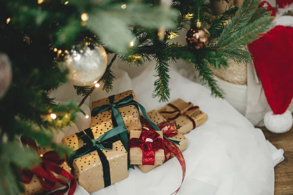 在有金色灯火的圣诞树下 有许多别致的圣诞礼物 在喜庆的现代房间里 用金纸包裹着圣诞礼物 上面有红色和绿色的缎带 圣诞快乐 节日快乐 — 图库照片