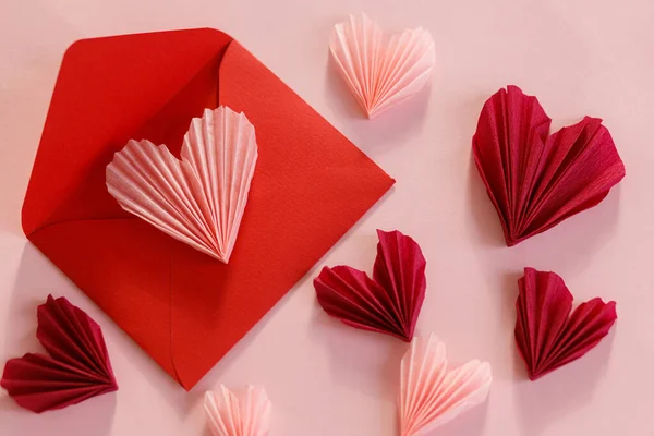 ハッピーバレンタインデー スタイリッシュなピンクのハートとレッドの封筒フラットピンクの紙の背景にレイアウト 現代のバレンタインデーの構成 ラブレターのコンセプト — ストック写真