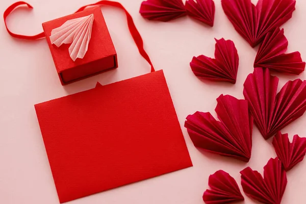 バレンタインデーのグリーティングカードのモックアップ 赤い紙の背景に空の赤いカード スタイリッシュなピンクの心と贈り物 テキストのためのスペースで創造的な現代的なモックアップ ハッピーバレンタインの日 — ストック写真