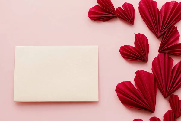 ハッピーバレンタインデー 空のカードとスタイリッシュな赤の心ピンクの紙の背景にフラットレイアウト テキストのためのスペースでモックアップ創造的な近代的なバレンタイングリーティングカード ラブレター — ストック写真