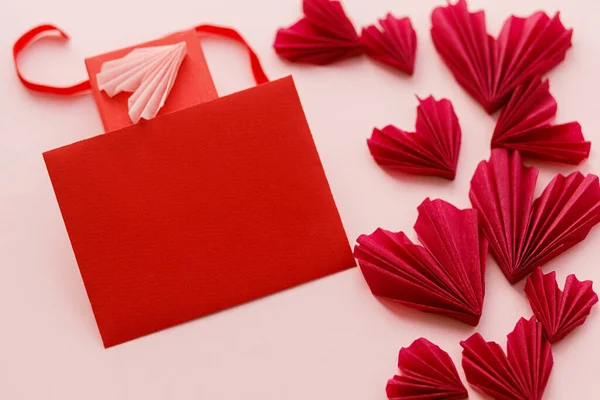 ハッピーバレンタインデー ピンクの紙の背景に赤いカードとスタイリッシュなピンクのハートを空にします テキストのためのスペースでモックアップ創造的な近代的なバレンタイングリーティングカード ラブレター — ストック写真