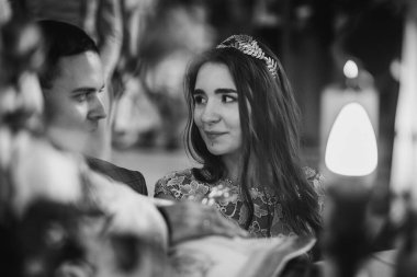 Tarz sahibi duygusal gelin ve damat kilisede evlilik sırasında kutsal kitaba el ele tutuşup yemin ediyorlar. Katedralde düğün töreni. Klasik evlilik yemini eden çift. Siyah ve beyaz resim