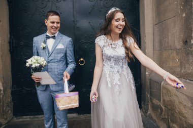 Mutlu gelin ve damat kutsal evlilikten sonra kilisenin arka planına şeker atıyor. Katedralde düğün töreni. Tatlı ile güzel duygusal evlilik çifti