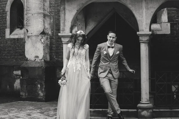 Avrupa şehrindeki güzel bir çiftin bulanık görüntüsü. Tarz sahibi gelin ve damat eski kilisenin arka planında kucaklaşıyorlar. Romantik bir an. Provence düğünü