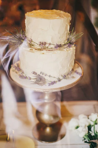 レストランでの結婚式のレセプションでテーブルの上にヴィンテージスタンドでラベンダーと絶妙な装飾を持つスタイリッシュな素朴な結婚式のケーキ モダンな美しいプロビンスウェディングケーキ 宴会での豪華なケータリング — ストック写真