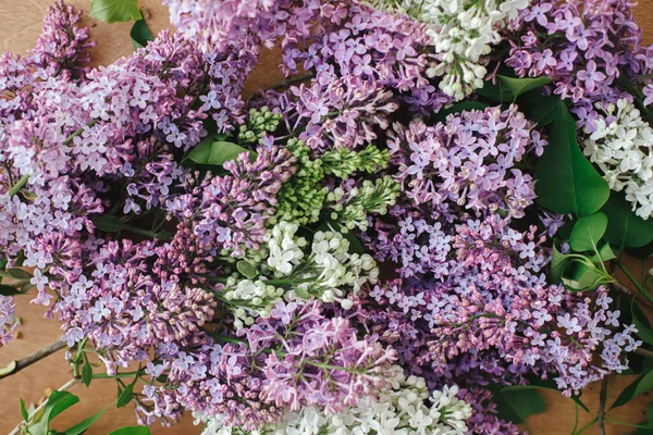 Ahşap arka planda güzel leylak çiçekleri. Kırsal masada renkli mor ve beyaz leylak dalları. Bahar kırsalında hayat devam ediyor, çiçekli bir görüntü. Anneler günün kutlu olsun.