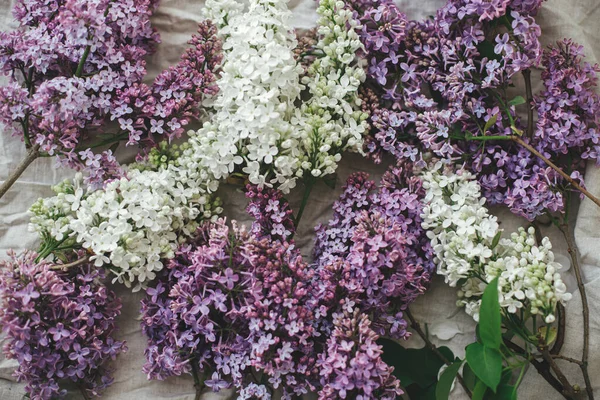 Beautiful lilac flowers on linen fabric top view. Colorful purple and white lilac branches on rustic background. Spring countryside still life, floral image. Happy mothers day