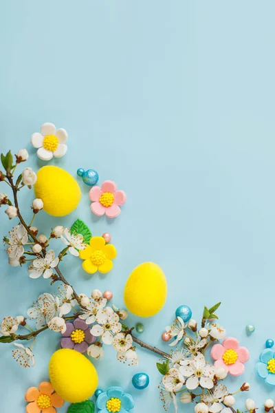复活节快乐 复活节彩蛋 糖果花和盛开的樱桃枝平铺在蓝色的背景上 具有文本空间的时尚的东方模板 贺卡或横幅 — 图库照片
