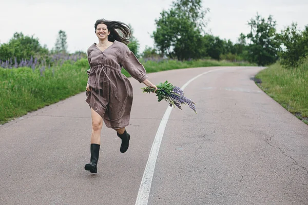 Feliz Mujer Despreocupada Vestido Rústico Corriendo Con Ramo Altramuz Campo — Foto de Stock