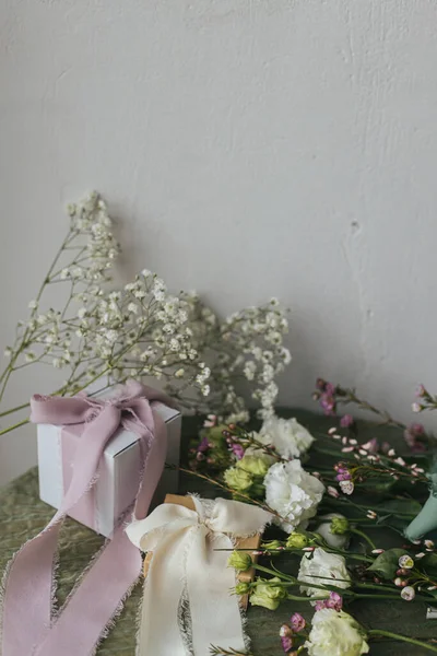 Stylowy Prosty Prezent Jedwabnymi Wstążkami Pięknymi Kwiatami Zielonym Tle Tkaniny — Zdjęcie stockowe