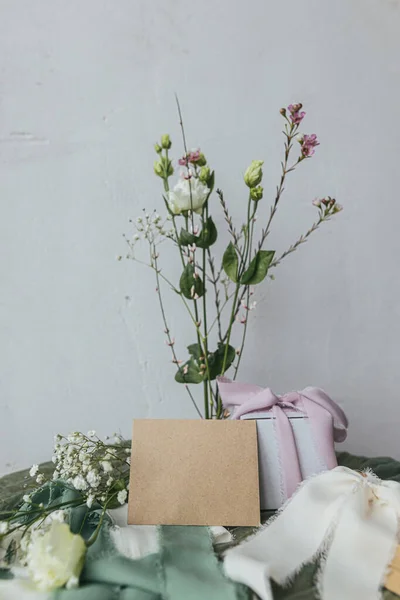 Stylowa Pusta Karta Prezent Piękne Kwiaty Wstążkami Zielonym Tle Tkaniny — Zdjęcie stockowe