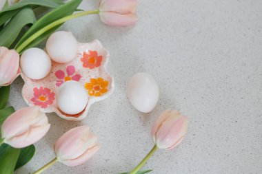 Mutlu Paskalyalar! Modern masada güzel laleler ve doğal yumurtalar. Fotokopi alanı olan şık bir Paskalya hayatı. Pembe laleli el yapımı yumurta tutacağı.