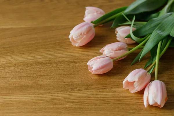 テキストのためのスペースを持つ木製のテーブルの上に美しいチューリップ 現代のイースターの装飾 スタイリッシュなピンクのチューリップの花束 幸せな母の日と女性の日 — ストック写真
