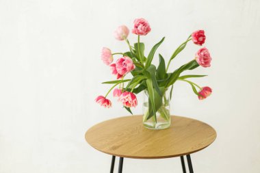 Kırsal odadaki ahşap masadaki vazoda duran güzel pembe laleler. Çiftlik evinde çiçek aranjmanı. Bahar çiçekleri kompozisyonu, kopyalama alanı. Anneler Gününüz kutlu olsun.