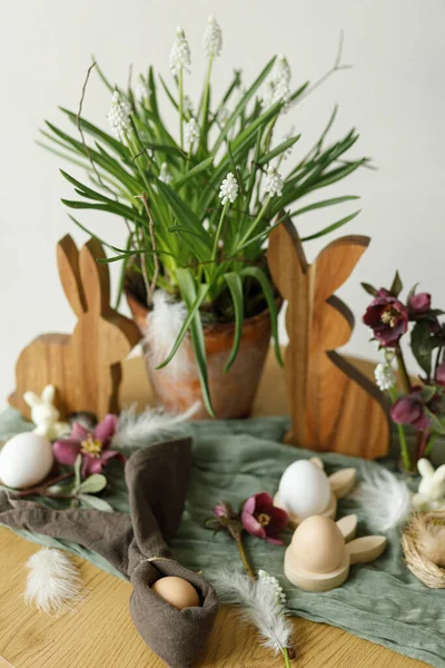 ハッピーイースター スタイリッシュな木製のウサギ 春の花 天然の卵 客室内の素朴なテーブルの上にナプキンのウサギの耳 イースターはまだ生きてる 農家でのお祭りの配置と装飾 — ストック写真