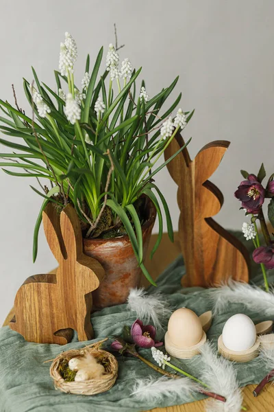 イースターはまだ生きてる 客室内の素朴なテーブルにスタイリッシュな木製のウサギ 春の花や天然の卵 ハッピーイースター 農家でのお祭りの配置と装飾 — ストック写真