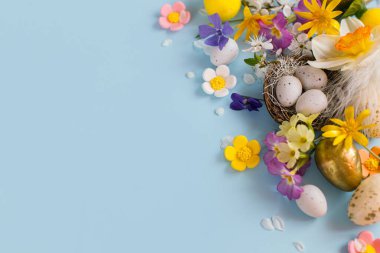Yuvada zarif Paskalya yumurtaları, renkli çiçekler ve mavi arka planda fotokopi alanı olan kiraz çiçekleri. Mutlu Paskalyalar! Tebrik kartı şablonu. Modern bayram afişi. Kutlama bileşimi