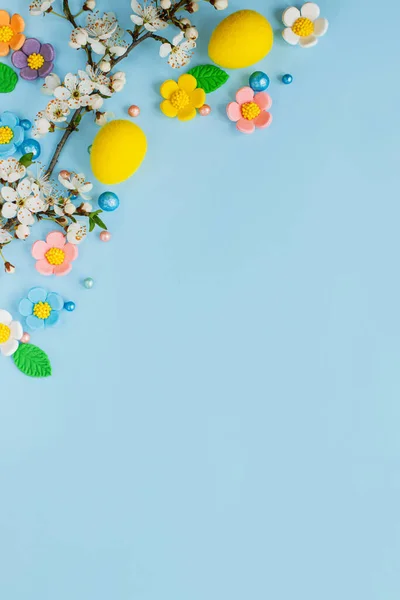 精美的复活节彩蛋 糖果花和樱花平铺在蓝色的背景上 还有复制的空间 复活节快乐 贺卡模板或现代假日横幅 — 图库照片