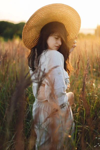 Hasır Şapkalı Şık Boho Kadın Gün Batımında Yabani Otların Arasında — Stok fotoğraf