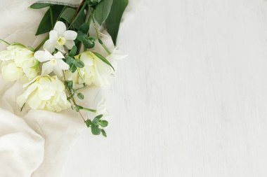 Anneler Günün kutlu olsun. Güzel beyaz laleler ve yumuşak kumaş üzerinde nergisler rustik ahşap masa düz metin için alan yatıyordu. Bahçeden güzel bir bahar buketi. Kadınlar Günü