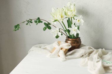 Anneler Günün kutlu olsun. Kırsal duvarlara karşı ahşap masanın üzerinde hediye kutusu olan güzel beyaz bir buket. Şık bahar laleleri ve eski vazodaki nergisler. Kadınlar Günü 'nde. Metin için boşluk