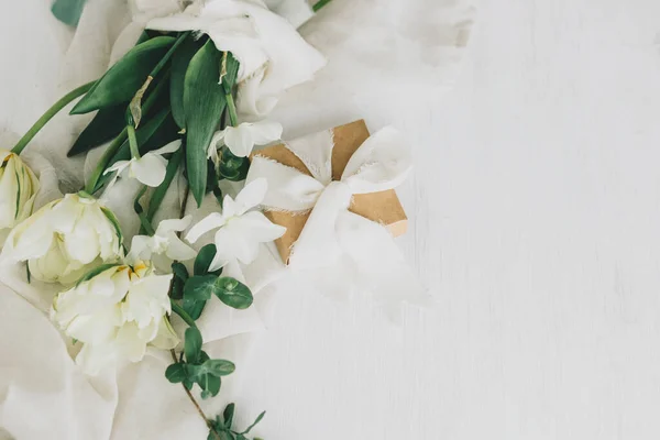 素朴な木製のテーブルフラットレイアウト上のギフトボックスと美しい白い花束 幸せな母の日 柔らかい生地にスタイリッシュな春のチューリップや水仙やプレゼント 女の日だ テキストのスペース — ストック写真
