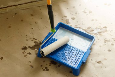 Paten fırçası ve tepsisi alçı duvarlar için yakın plan. Ev ve ev yenileme konsepti. Yeni binadaki duvarların hazırlanma süreci