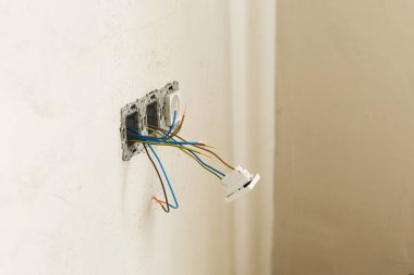 Prizi ve düğmesi olan elektrik kutusu. Alçılı duvara elektrik konnektörü yerleştiriliyor. Ev ve ev yenileme konsepti. Kablo