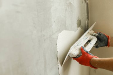 Alçı taşı ve spatulayla duvarları sıvayan bir işçi. Ev ve ev yenileme konsepti. # Yaklaş sıva ve becerikli ellerin malayla #