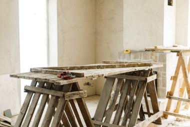 Ev ve ev yenileme konsepti. Ahşap merdiveni, şöminesi, alçı duvarları ve yeni binası olan bitmemiş bir oturma odası. Ev geliştirme