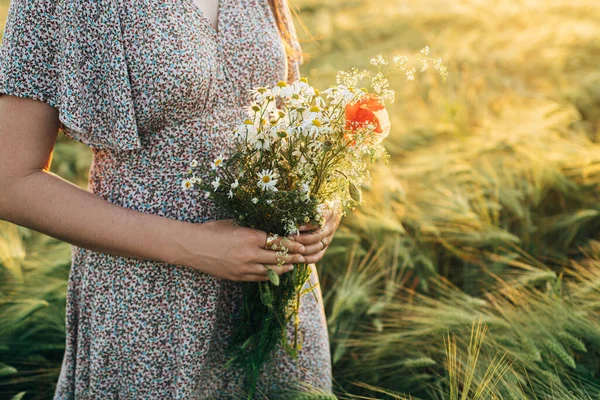 Arpa Tarlasında Gün Batımında Kadın Ellerinde Güzel Kır Çiçekleri Buketi — Stok fotoğraf