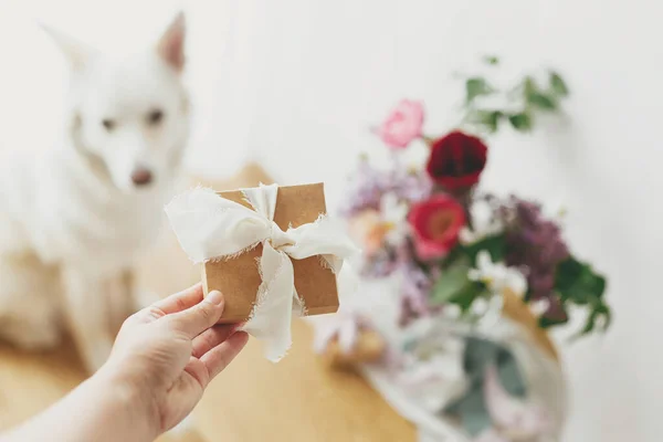 Χέρι Κρατώντας Κομψό Κουτί Δώρου Στο Παρασκήνιο Του Χαριτωμένο Σκυλί — Φωτογραφία Αρχείου