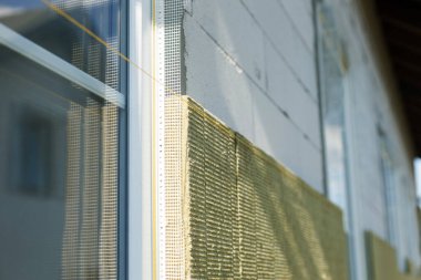 Mineral yünü, termal gelişim ve enerji tasarrufu ile yalıtım malzemesi. Modern çiftlik evinin yenilenmesi, taştan yün panellerle kaplanıyor. Ev yalıtımı kavramı