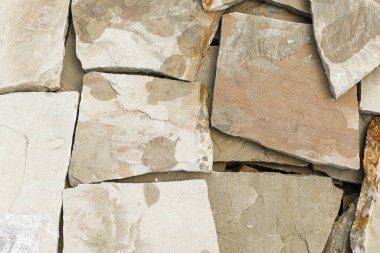 Kumtaşı yaklaş. Kum taşı karoları kapanıyor, ev yenileme konsepti. Ham kaya, mineral doğal kumtaşı ile kaplanmış ön cephe için