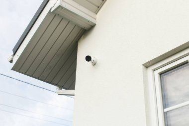 Beyaz cephe duvarlarında güvenlik kameraları var. Kapalı devre güvenlik sistemi. Çiftlik evinin dış emlak korumasındaki modern kameralar. Ev güvenliği kavramı