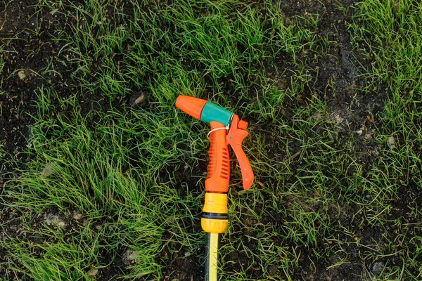 stock image Hosepipe with sprayer on green grass top view. Watering lawn concept. Water sprinkler for garden