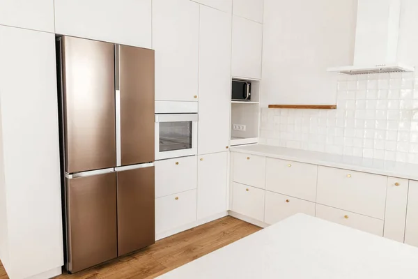 现代最小厨房设计 现代厨房的内部 新丑闻中时尚的白色厨房橱柜 装有黄铜把手 花岗岩岛和家用电器 — 图库照片