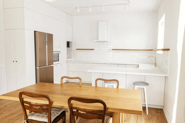 モダンなキッチンインテリア 新しい北欧の家で真鍮ノブ 花崗岩カウンター 家電製品や素朴な木製のテーブルとスタイリッシュな白いキッチンキャビネット モダンなミニキッチンデザイン — ストック写真