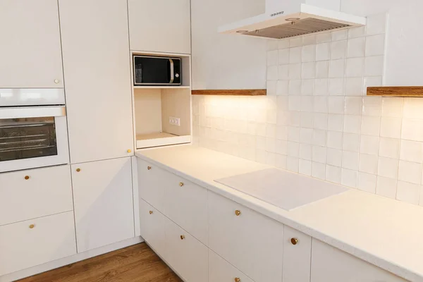 モダンなキッチンインテリア 真鍮のノブ 花崗岩のカウンター 新しい北欧の家の光と家電付きの木製の棚とスタイリッシュな白いキッチンキャビネット モダンなミニキッチンデザイン — ストック写真