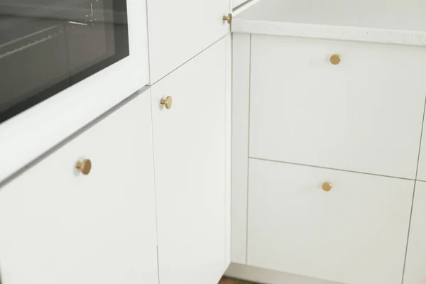 现代厨房的内部 时尚的白色厨房橱柜与黄铜旋钮和电炉关闭在新的丑闻鸟的房子 现代最低厨房设计 — 图库照片
