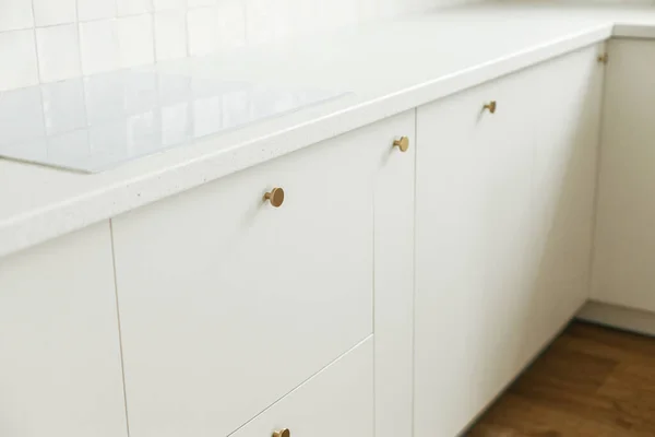现代厨房的内部 在新的丑闻中 风格别致的白色厨房橱柜 装有黄铜把手 花岗岩台面和电炉 现代最小厨房工作台 — 图库照片