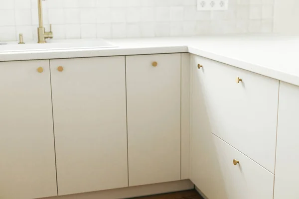 现代厨房的内部 在新的丑闻中 风格别致的白色厨房橱柜与黄铜旋钮和花岗岩台面紧密相连 现代最小厨房工作台 — 图库照片
