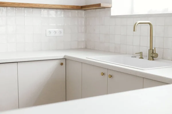 现代厨房的内部 时尚的白色厨房橱柜 配有黄铜水龙头 花岗岩岛 木制货架和新丑闻中的家用电器 现代最低厨房设计 — 图库照片