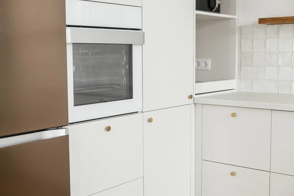 现代最小厨房设计 时尚的白色厨房橱柜 有黄铜把手 木制架子和新丑闻中的家用电器 现代厨房内部 — 图库照片