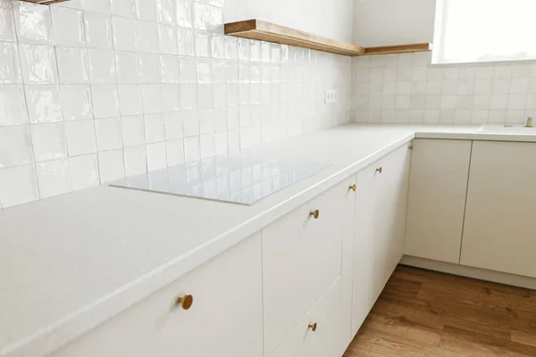 现代厨房的内部 在新的丑闻中 用黄铜把手 白色瓷砖和木制架子装饰着时尚的白色厨房橱柜 现代最低厨房设计 — 图库照片