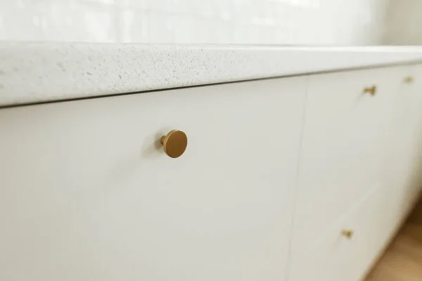 在新的丑闻中 风格别致的白色厨房橱柜与黄铜旋钮和花岗岩台面紧密相连 现代厨房的内部 现代最小厨房工作台 — 图库照片