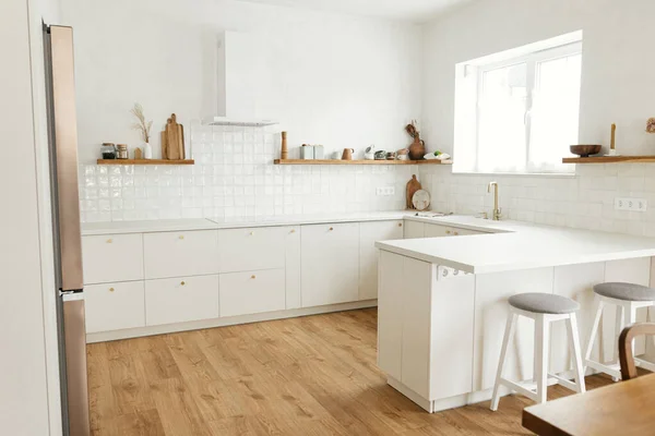 现代最小厨房设计 时尚的白色厨房橱柜与黄铜把手 木制架子与器具和器具在新的丑闻鸟的房子 现代厨房内部 — 图库照片