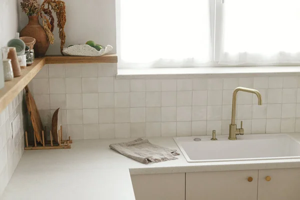 现代厨房的内部 时尚的白色厨房橱柜 黄铜水龙头和花岗岩水池 新丑闻中的木制架子上的器皿 现代最低厨房设计 — 图库照片