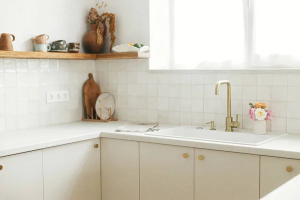 现代最小厨房设计 在新的丑闻中 风格别致的白色厨房橱柜 配有黄铜水龙头 花岗岩台面和带有器皿的木制架子 现代厨房内部 — 图库照片