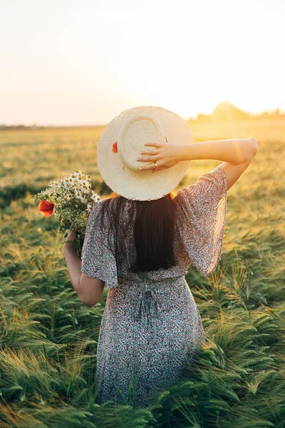 Schöne Frau Mit Hut Und Wildblumenstrauß Steht Gerstenfeld Sonnenuntergang Stilvolle — Stockfoto
